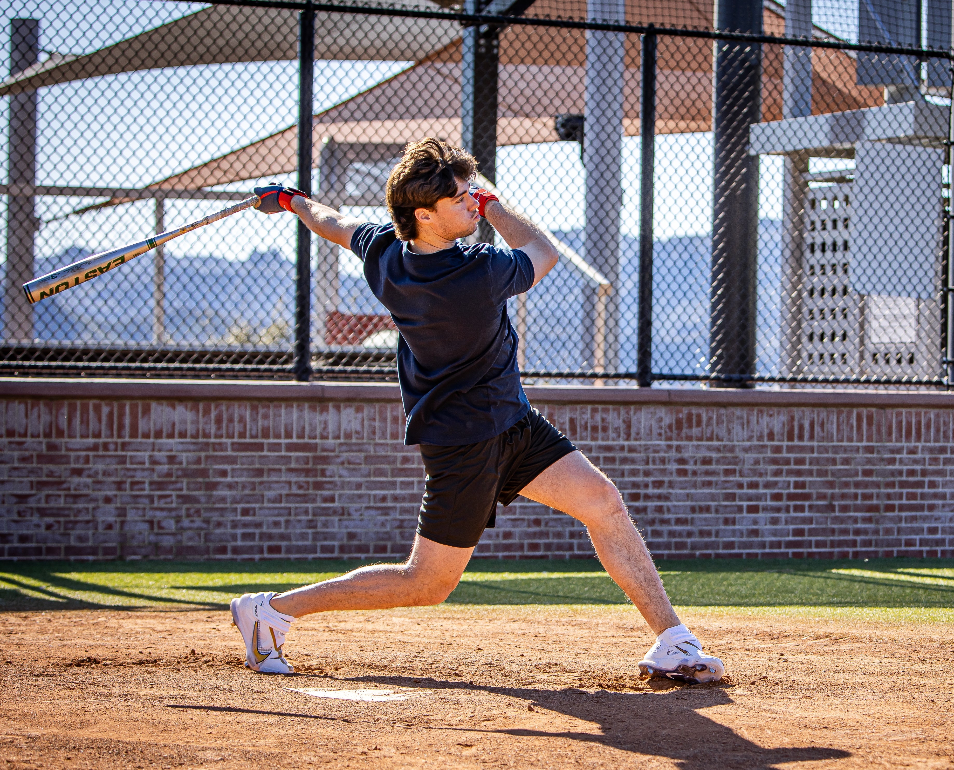 Person playing baseball on a rooftop with cityscape in the background