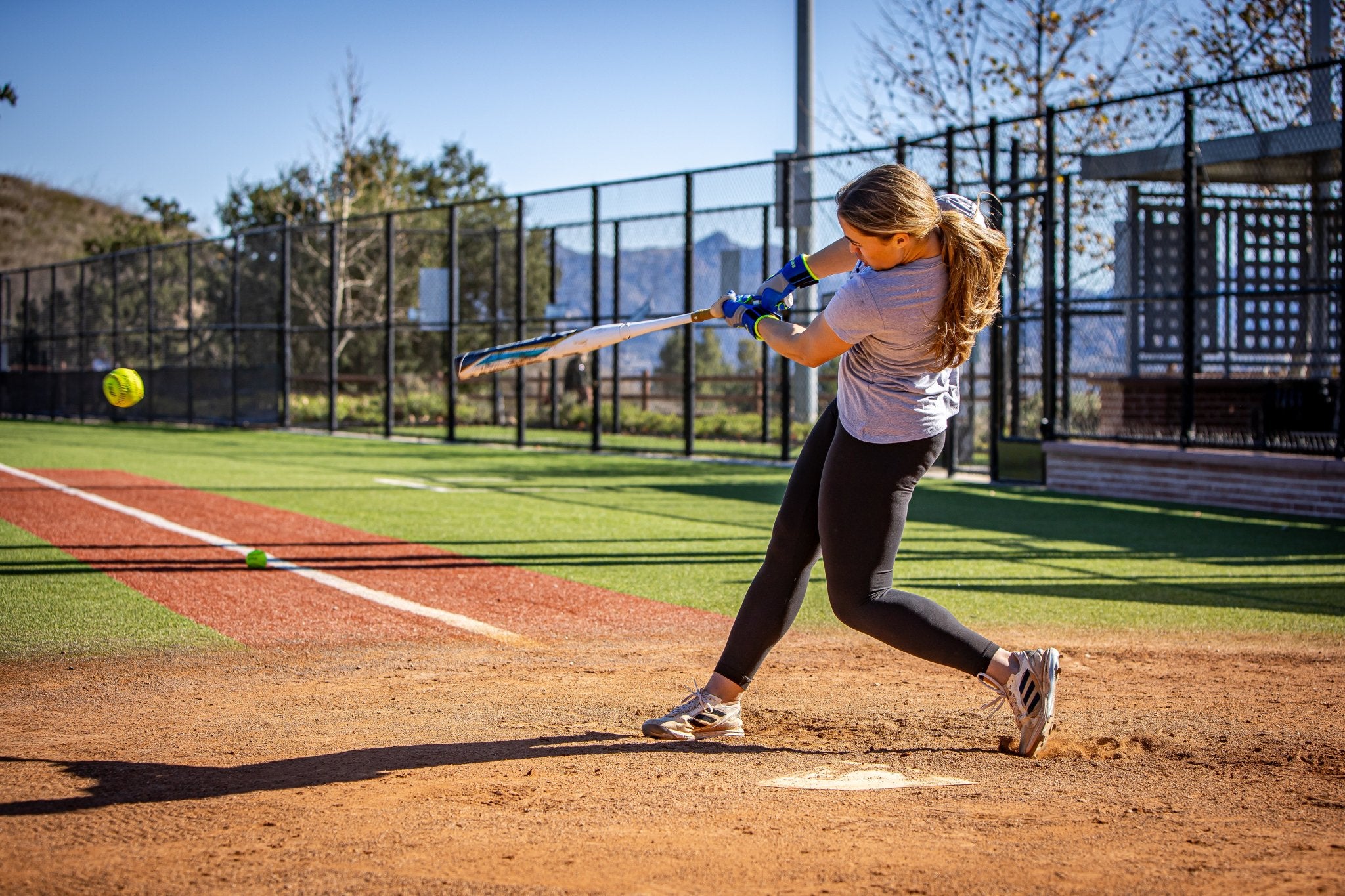 Person playing softball on a field with a clear sky